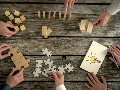 campuslab-innovation Dienstleistungen: Hände von Seminarteilnehmenden setzen verschiedene Bausteine zusammen