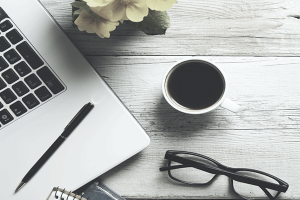 Banner_Landing_Page_600x400 Tisch mit Laptop, Brille und Kaffeetasse